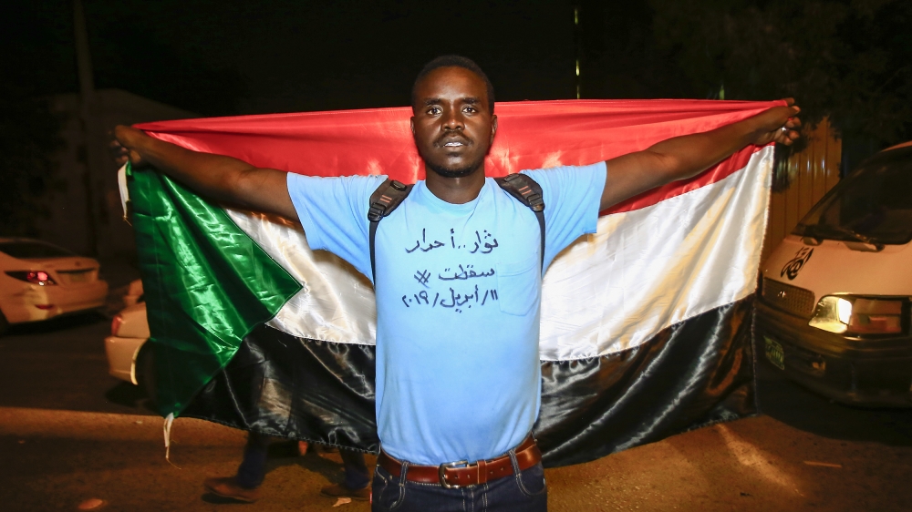 A Sudanese protester demonstrates with a national flag during a demonstration against Sudan's new ruling military council [Ashraf Shazly/ AFP]
