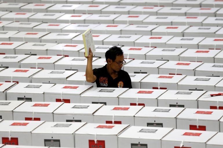 A worker carries election materials as he prepares ballot boxes before their distribution to polling stations in a warehouse in Jakarta, Indonesia, April 15, 2019. REUTERS/Willy Kurniawan