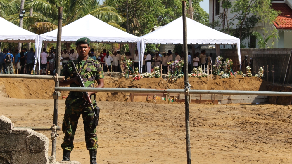 The mass funeral was guarded by members of Sri Lanka's armed forces [Kate Mayberry/Al Jazeera]