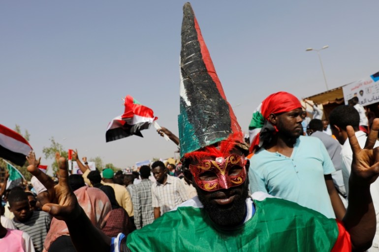 A Sudanese protester makes a victory sign outside the defense ministry compound in Khartoum
