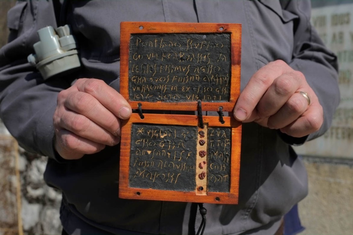A local guide for the state museum in Ro?ia holds up a replica of a Roman wax tablet found in the Roman galleries. The particularity of the tablets, as opposed to others found across the range of the