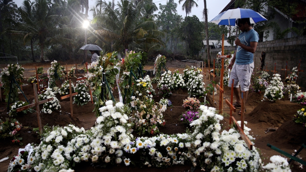 People come to the site of a mass burial to pay their respects to victims of Easter Sunday bombings [Athit Perawongmetha/ Reuters]