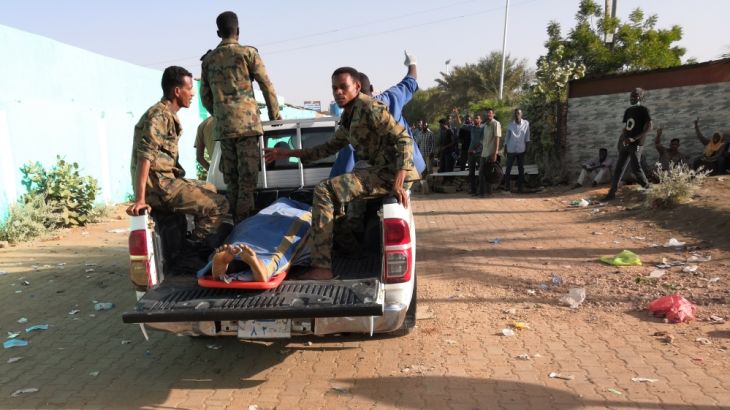 Sudanese soldiers transport a body covered in cloth in a pick-up truck from the area around the military headquarters in the capital Khartoum during anti-government protests on April 9, 2019