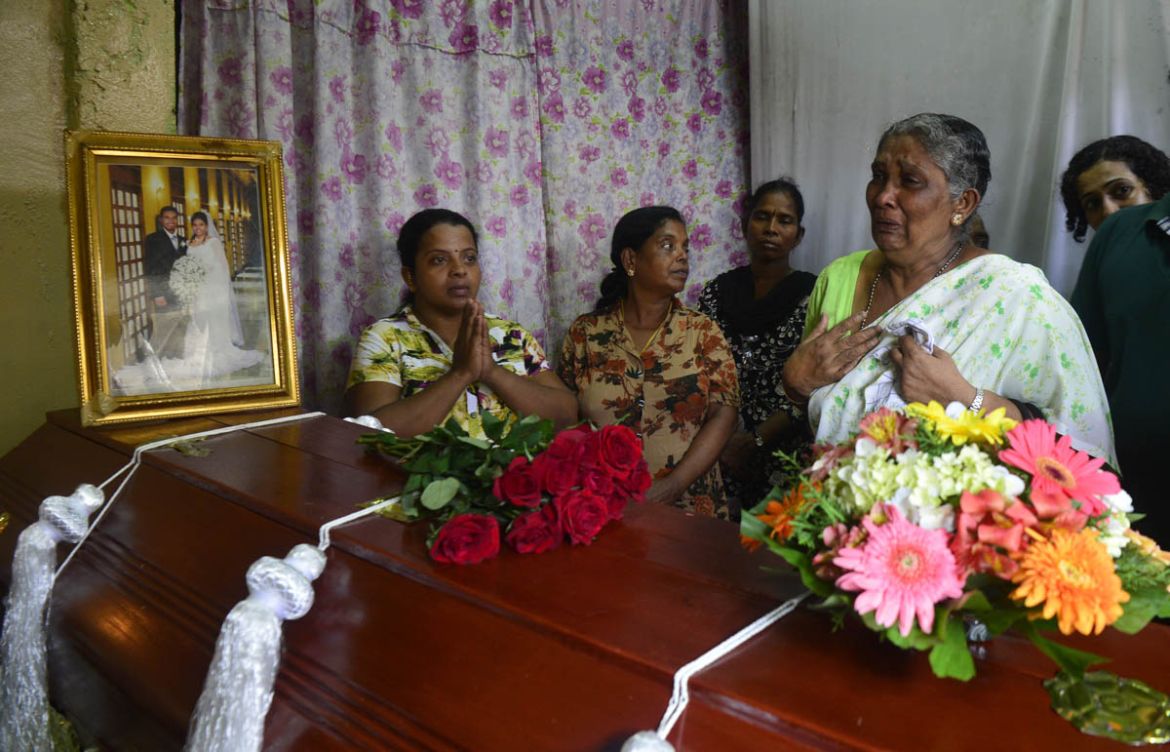 A Sri Lankan woman cries next to the coffins of relatives who died in an explosion at St. Anthony''s Shrine on Easter Sunday, in Colombo on April 23, 2019. Sri Lanka fell silent for three minutes April