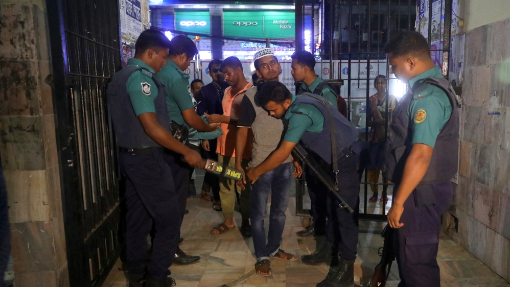 Security personnel check Muslims at the entrance of the Baitul Mukarram National Mosque as security has been increased after the series of blasts [Mohammad Ponir Hossain/Reuters]