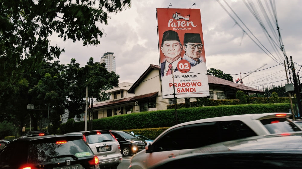 A billboard for Indonesian presidential candidate Prabowo Subianto and his running mate Sandiaga Uno over a busy street in the capital, Jakarta [Kate Walton/Al Jazeera]