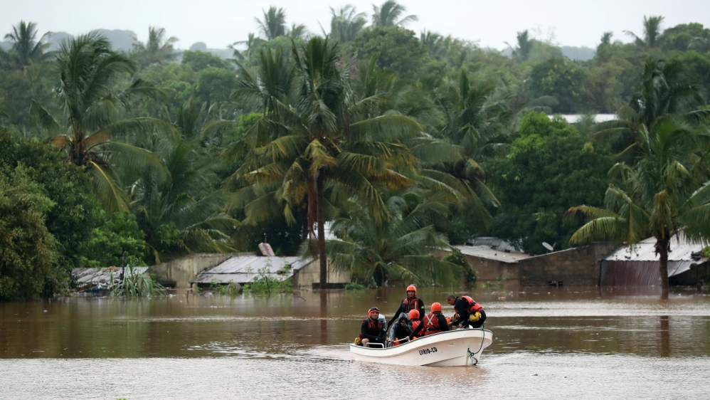 Search and rescue officials pass by submerged houses in a Pemba neighbourhood [Mike Hutchings/Reuters]
