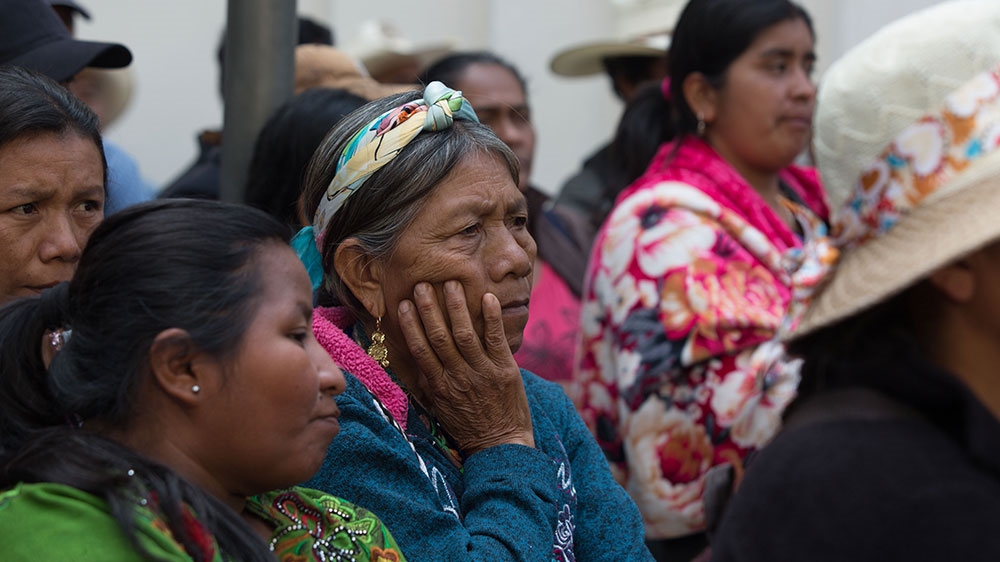 Achi Mayan women listen to a speech by Antonio Vasquez demanding a dialogue with the Guatemalan President Jimmy Morales [Jeff Abbott/Al Jazeera] 