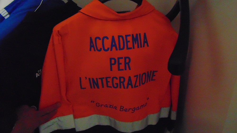 This orange uniform which must be worn by the refugees bears the words 'Thank you Bergamo' [Giorgio Ghiglione/Al Jazeera]
