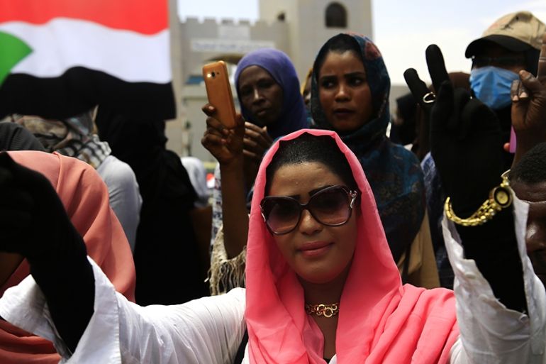 A Sudanese woman waves a national flag as demonstrators gather during a rally in the area of the military headquarters in the capital Khartoum on April 16, 2019. - Protesters in Sudan toughened their