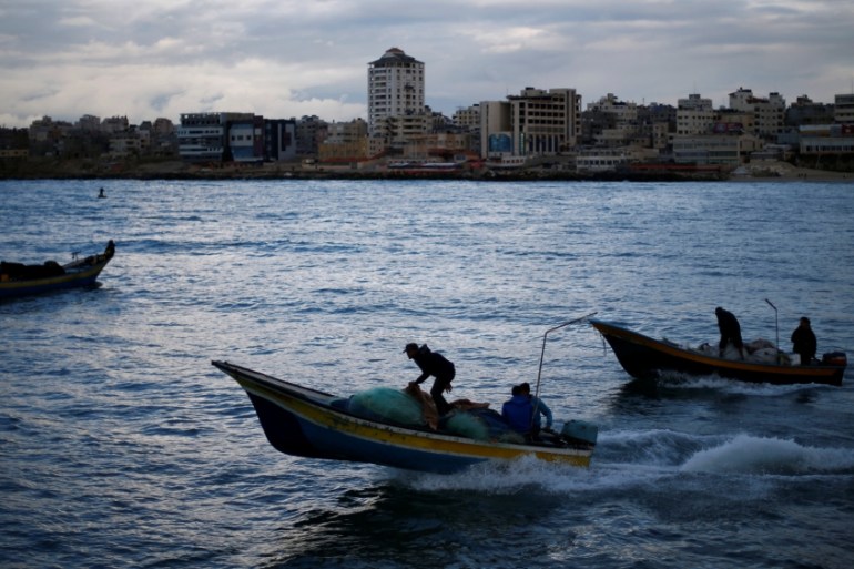 Palestinian fishermen ride boats at the seaport of Gaza City