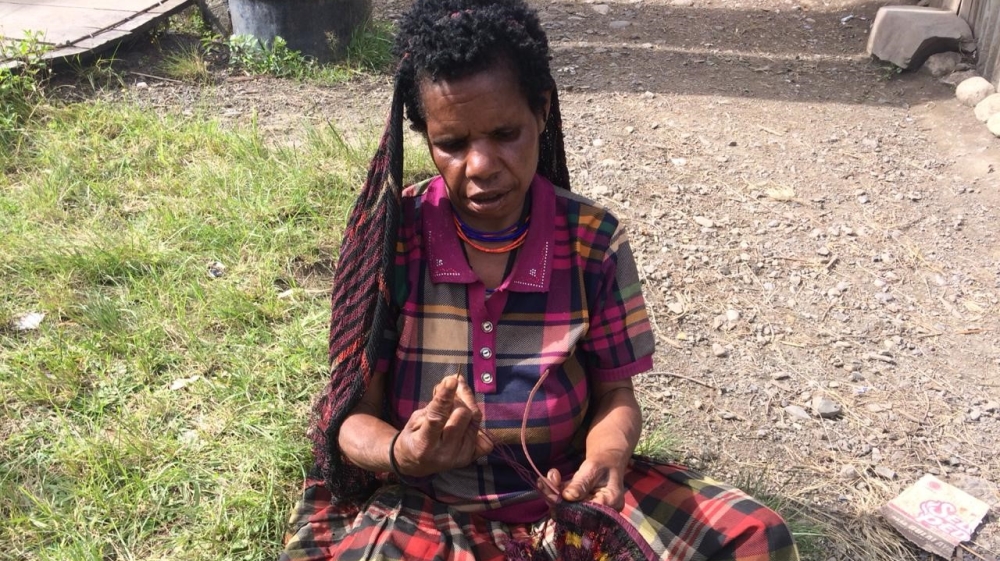 A woman with a traditional noken [Febriana Firdaus/Al Jazeera]