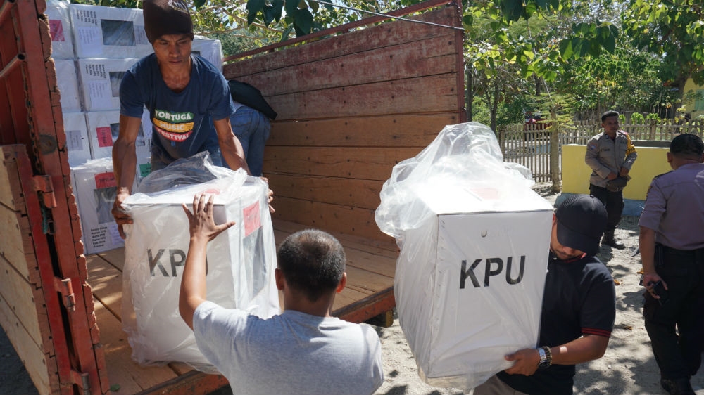 Workers unload ballot boxes and other election equipment in preparation for Indonesia's election on Wednesday. KPU is the Indonesian acronym for the country's elections commission. [Ian Morse/Al Jazeera]
