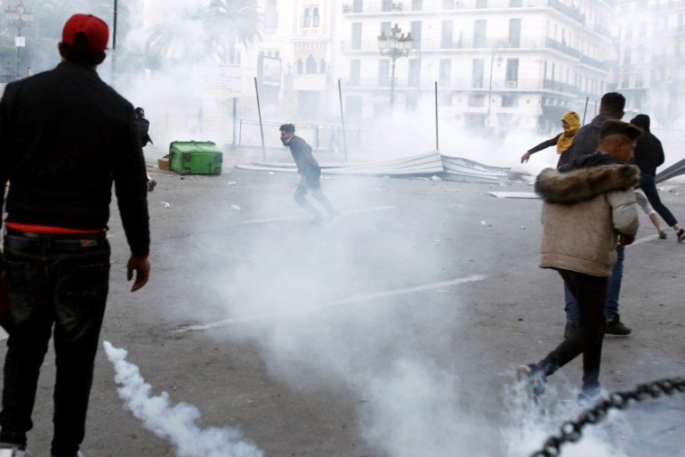 Anti-riot police fire tear gas as they confront some youths after a protest in Algiers