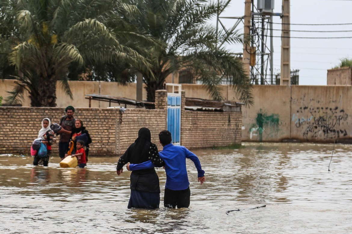 An Iranian family walks through a flooded street in a village around the city of Ahvaz, in Iran''s Khuzestan province, on March 31, 2019. Iranian authorities ordered the immediate evacuation of flood-s