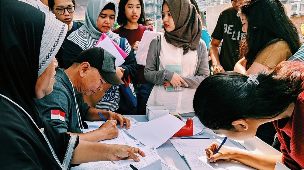 Voters wait for their turn to register at a polling station in central Jakarta [Kate Walton/Al Jazeera]