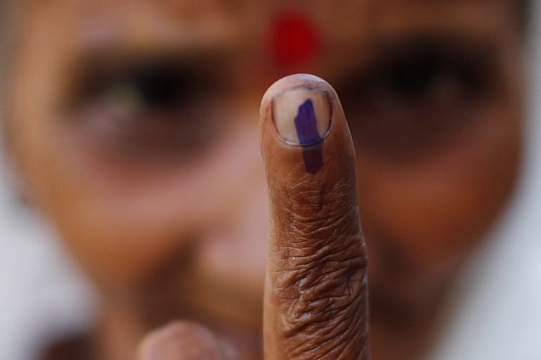 A woman shows her ink-marked finger after casting her vote at a polling station in Majuli, a large river island in the Brahmaputra river, in the northeastern Indian state of Assam.