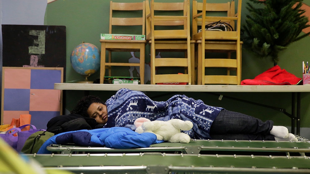A Central American immigrant seeking asylum rests on a cot at Travis Park Church, which is serving as a makeshift shelter in downtown San Antonio [Eric Gay/AP Photo] 