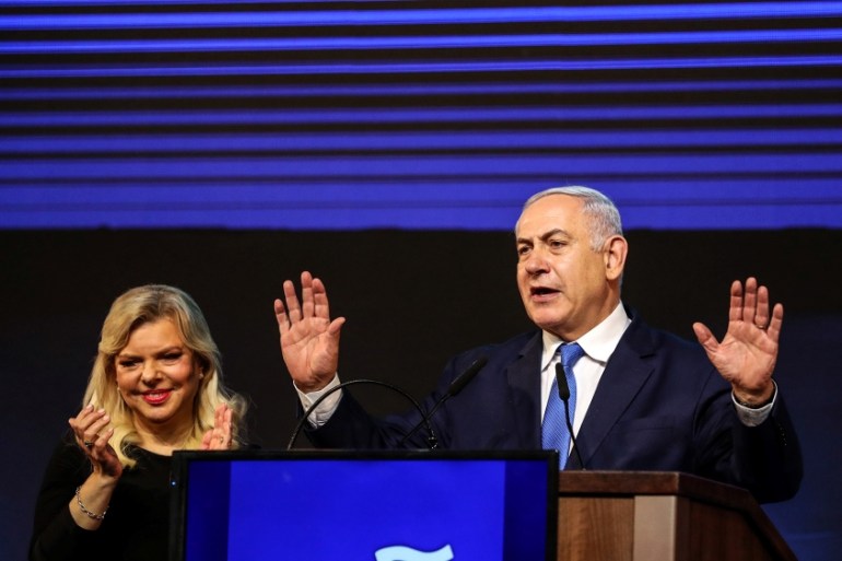 Israeli Prime Minister Benjamin Netanyahu and his wife Sara gesture as Netanyahu speaks following the announcement of exit polls in Israel''s parliamentary election at the party headquarters in Tel Av