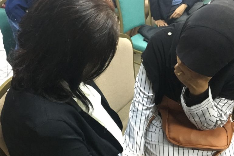 Norhayati Ariffin (right - wife of Amri Che Mat) comforted by Susanna Liew (wife of Raymond Koh) after an enquiry finds her husband was most likely disappeared by Malaysia’s Special Branch.