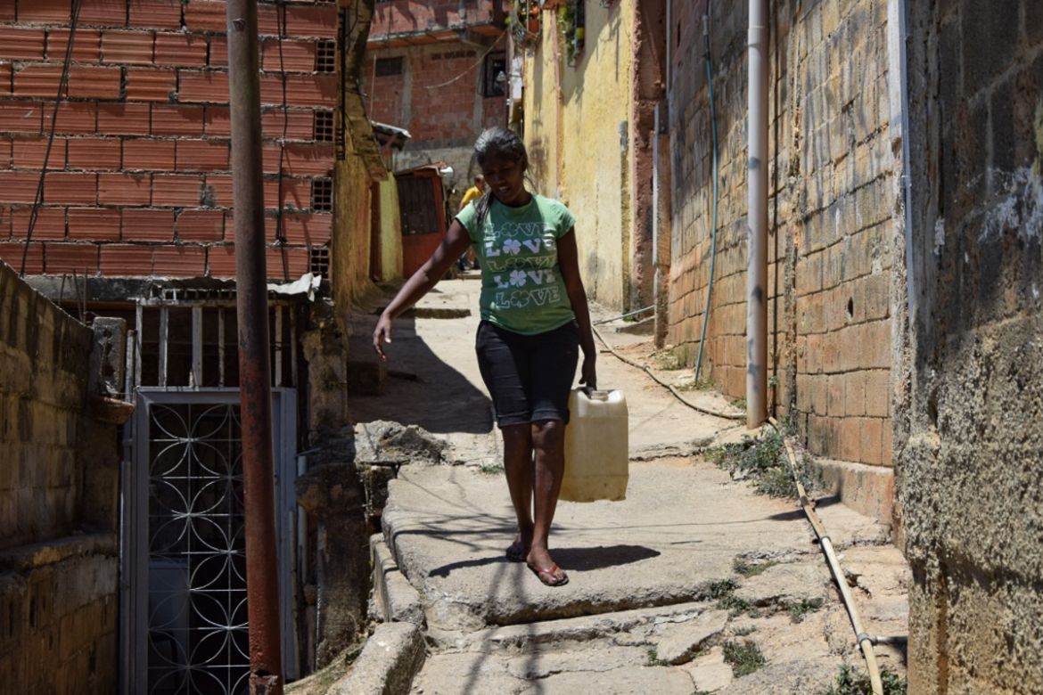“I have spent 27 years carrying water,” Elena said, there is never water in this neighbourhood” [Elizabeth Melimopoulos/Al Jazeera]