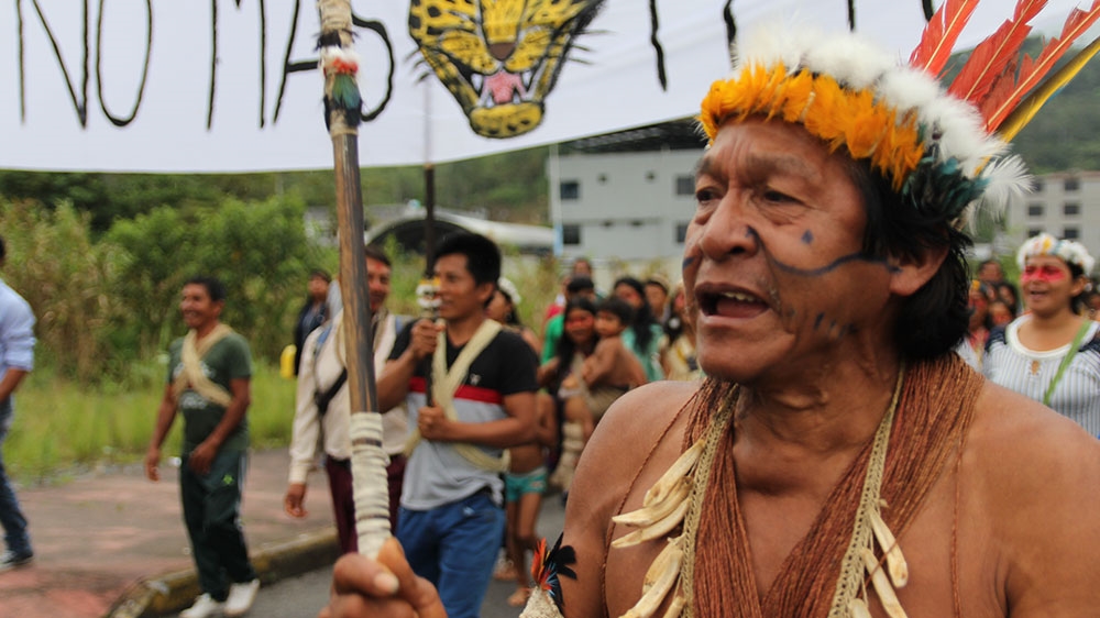 
A Waorani man sings as hundreds of community members and supporters march to thejudicial office in Puyo Thursday [Kimberley Brown/Al Jazeera]
