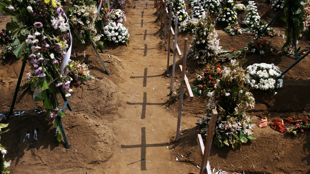 Crosses cast shadows at the site of a mass burial in Negombo [Athit Perawongmetha/Reuters]