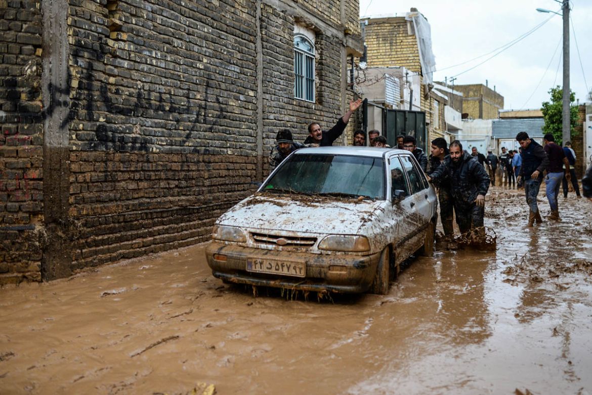 Men push a vehicle after a flash flooding in Shiraz, Iran, March 26, 2019. Tasnim News Agency/via REUTERS ATTENTION EDITORS - THIS PICTURE WAS PROVIDED BY A THIRD PARTY