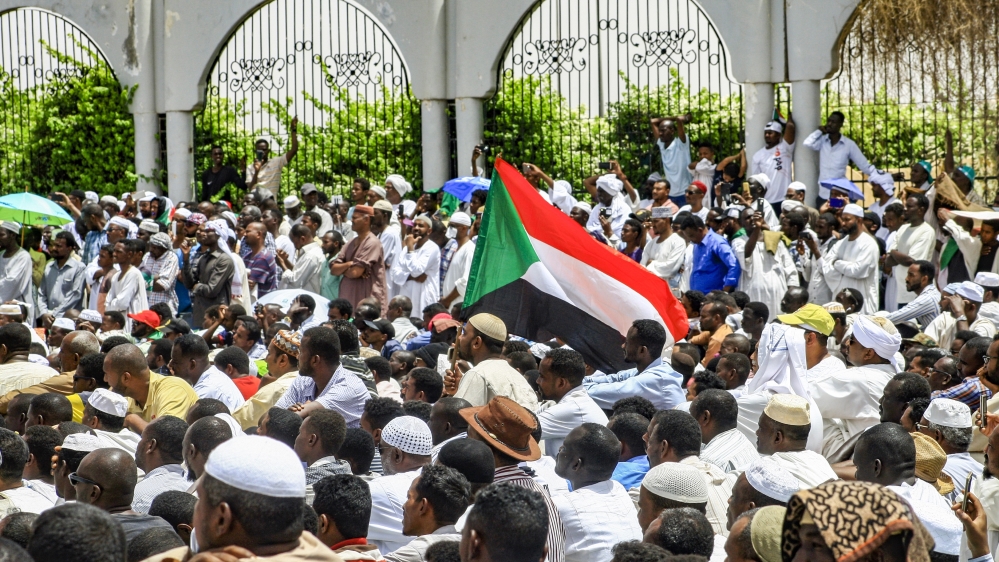 Sudanese men attend a Friday prayer sermon during a rally - demanding a civilian body to lead the transition to democracy - outside the army headquarters in Khartoum [Mohammed Hemmeaida/AFP]