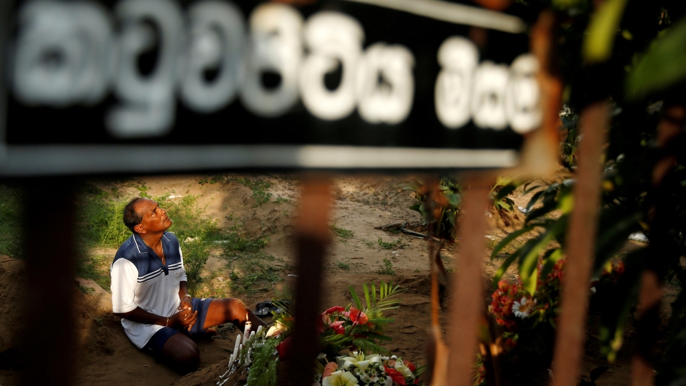 A man mourns at a grave of a victim at Sellakanda Catholic cemetery in Negombo [Thomas Peter/Reuters]