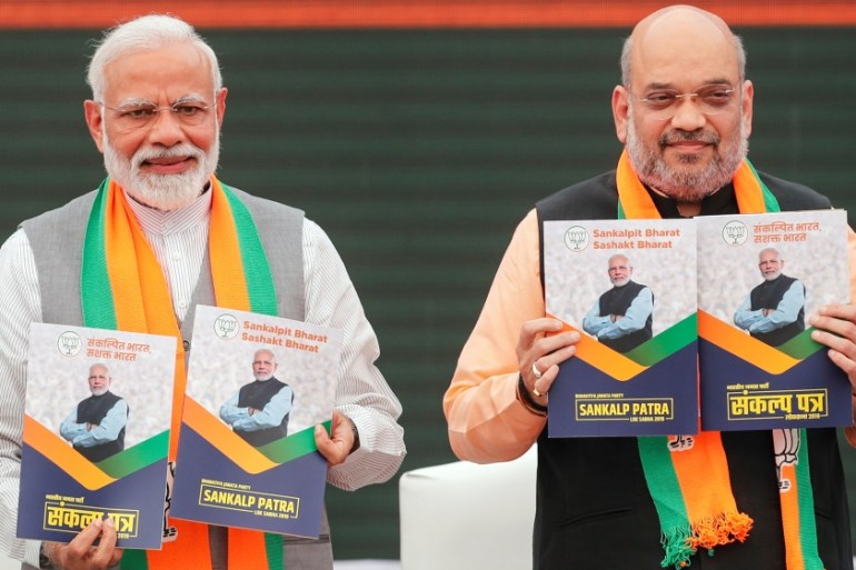 Indian PM Narendra Modi and chief of India''s ruling Bharatiya Janata Party (BJP) Amit Shah, display copies of their party''s election manifesto for the April/May general election in New Delhi