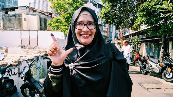 Moli, a Prabowo voter, shows off her inked finger after voting in Central Jakarta [Kate Walton/Al Jazeera]