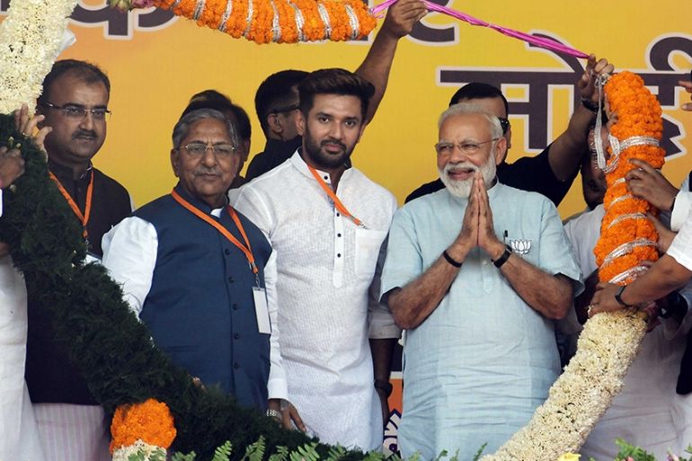 Indian Prime Minister Narendra Modi (C) gestures while being garlanded during a public rally, ahead of the Lok Sabha elections, in Jamui on April 2, 2019. - India is holding a general election to be h