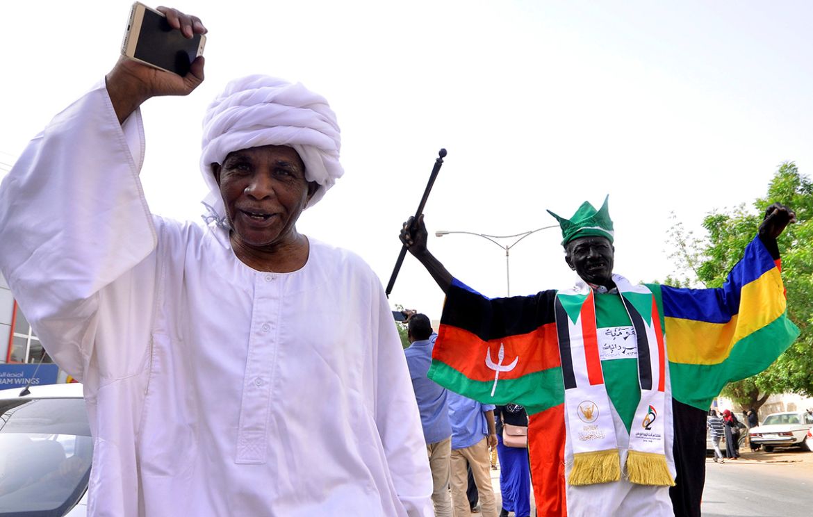 Demonstrators chant slogans along the streets after Sudan''s Defense Minister Awad Mohamed Ahmed Ibn Auf said that President Omar al-Bashir had been detained "in a safe place" and that a military counc