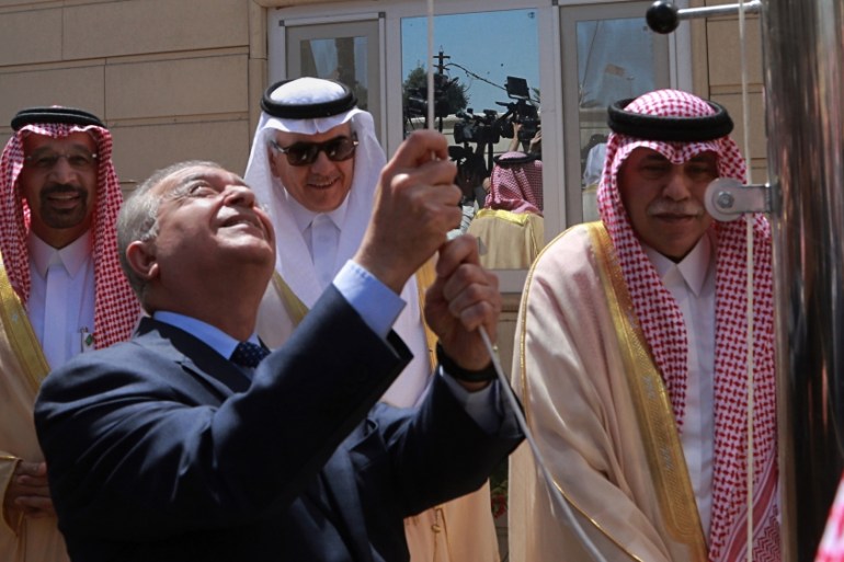 Iraq Foreign Minister Mohamed Alhakim raises the Saudi flag