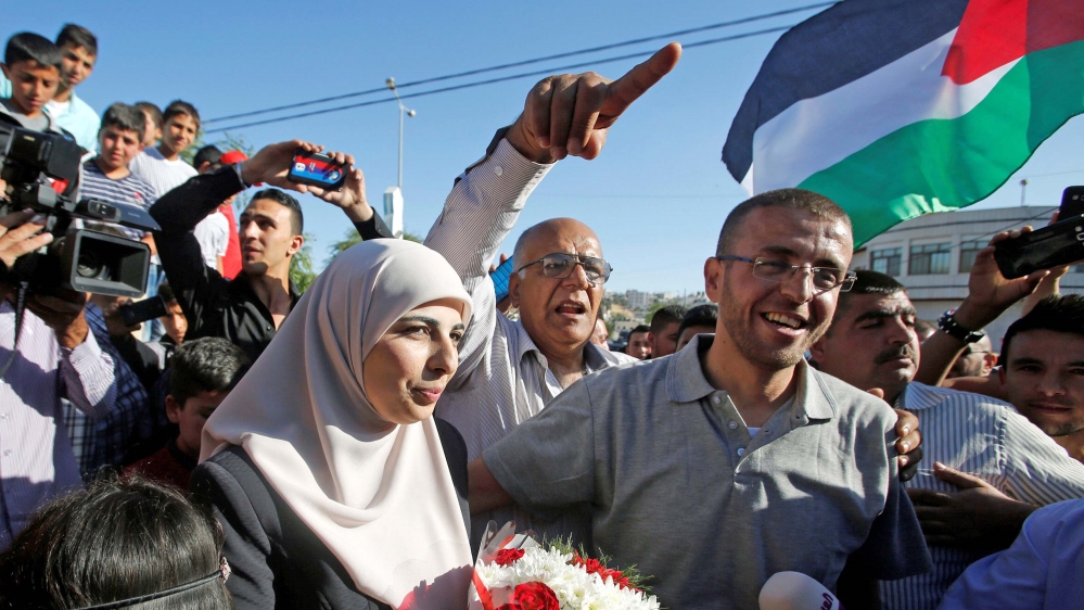 Freed Palestinian journalist Mohammad al-Qiq, who was arrested by Israel last November and went on a 94-day hunger strike to protest against his detention without charge, stands next to his wife Faiha upon his release in the West Bank town of Dura, on May 19, 2016 [File: Reuters/Mussa Qawasma]