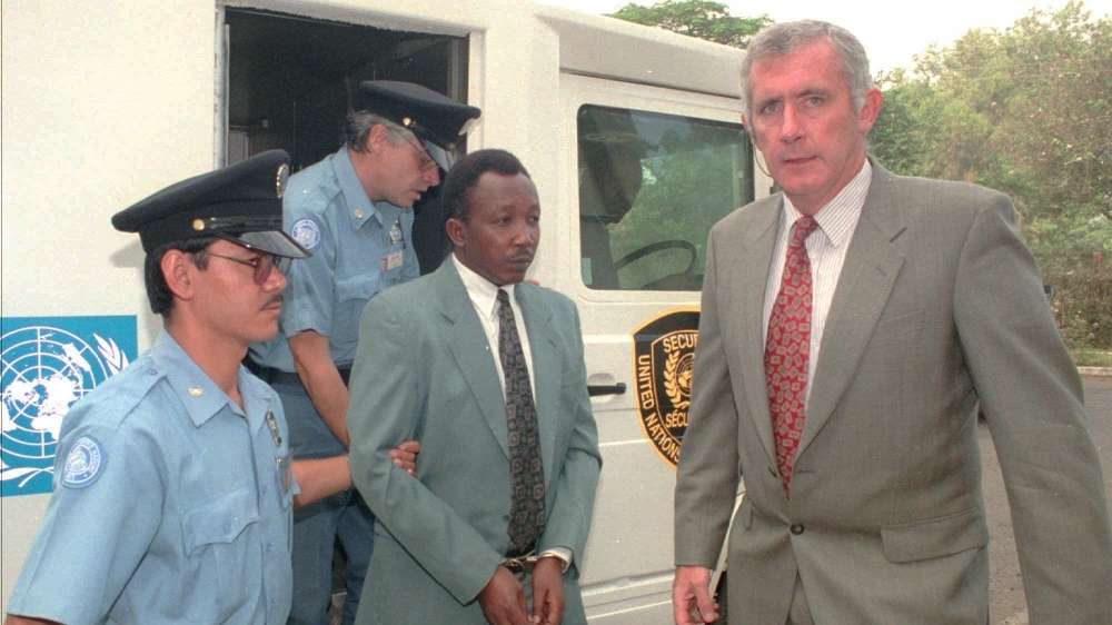 Jean-Paul Akayesu, handcuffed and surrounded by UN security personnel, arrives at the International Criminal Tribunal for Rwanda in Arusha, Tanzania on January 9, 1997 [File: Sayyid Azim/AP]