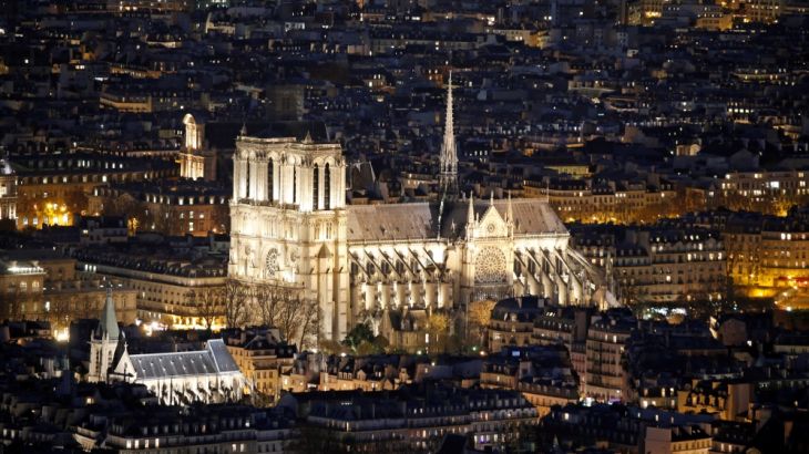 FILE PHOTO: A general view shows the Notre Dame Cathedral and rooftops at night in Paris