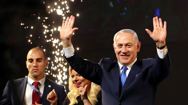 Israeli Prime Minister Benjamin Netanyahu and his wife Sara react as they stand on stage following the announcement of exit polls in Israel''s parliamentary election at the party headquarters in Tel A