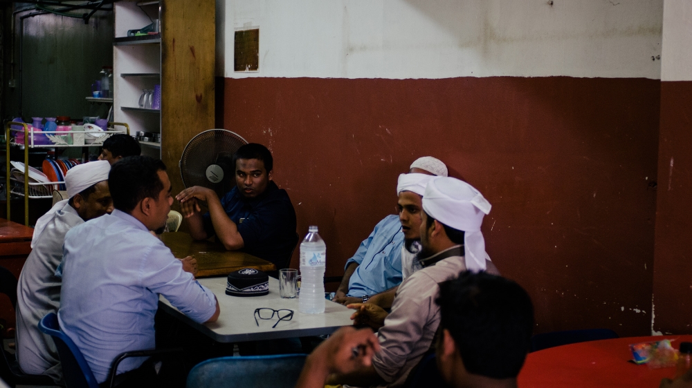A group of Rohingya men sit in a cafe in Kuala Lumpur [Kaamil Ahmed/Al Jazeera]