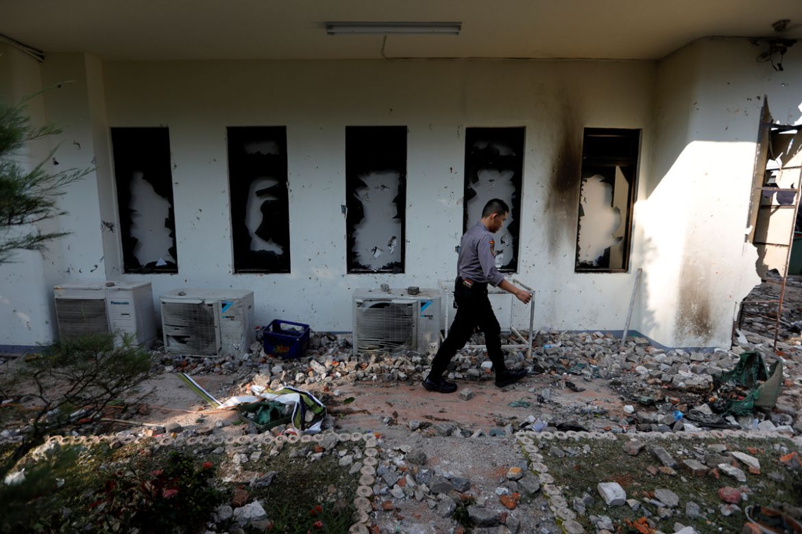 A policeman walks past a damaged window after last night''s riot following the announcement of last month''s presidential election results at the Election Supervisory Agency (Bawaslu) headquarters in Ja