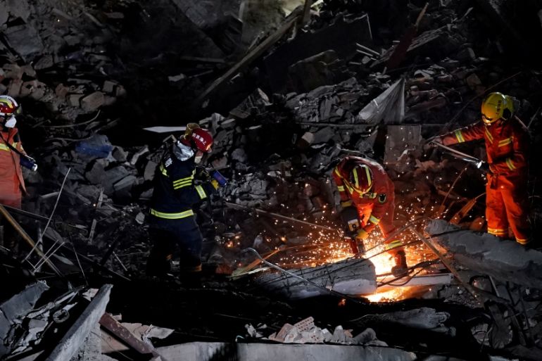 Firefighters work at the site where a building collapsed, in Shanghai
