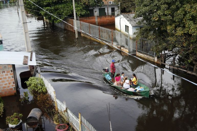 A boat transports people displaced by a flooded street in Asuncion, Paraguay, Wednesday, May 8, 2019. Officials in Paraguay say they have had to evacuate some 40,000 people in recent weeks because of
