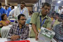Election staff members count votes at a vote counting centre in Mumbai