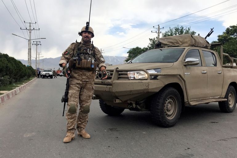 An Afghan security forces member stands guard at the site of a blast in Kabul, Afghanistan