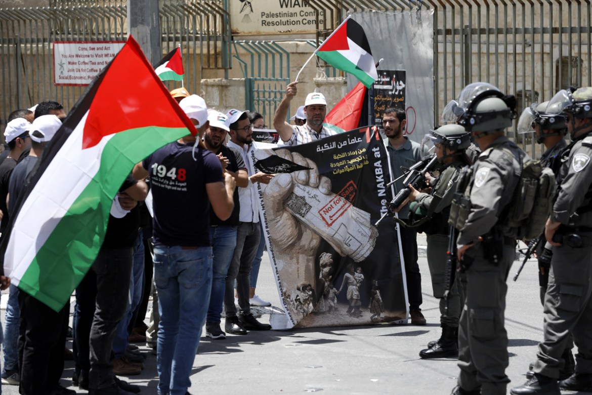 Palestinians hold placards and flags during a protest to mark the 71st anniversary of Nakba or catastrophe in the West Bank city of Bethlehem, 15 May 2019. Nakba Day, or Day of the Catastrophe, which