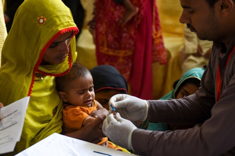 In this image taken on May 9, 2019, a Pakistani paramedic takes a blood sample from a baby for a HIV test at a state-run hospital in Rato Dero in the district of Larkana of the southern Sindh province