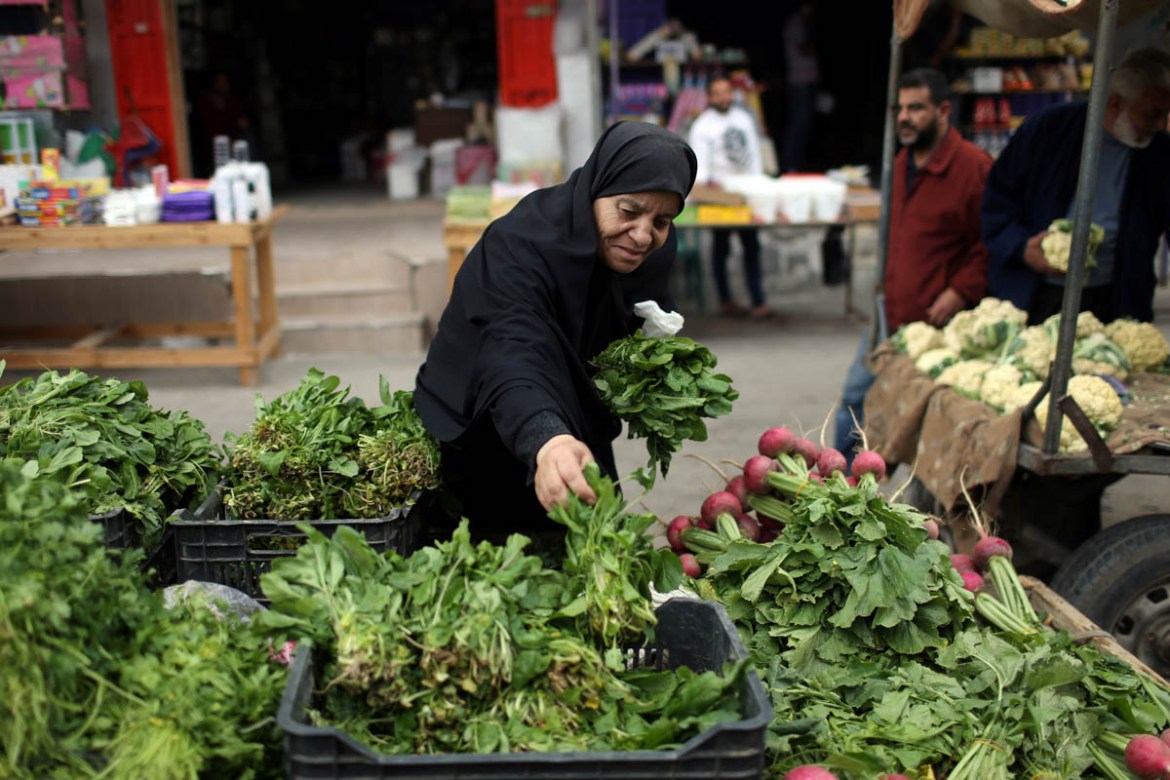 A Palestinian woman sells vegetables on the first day of the Muslim holy month of Ramadan, in the southern Gaza Strip May 6, 2019. REUTERS/Ibraheem Abu Mustafa