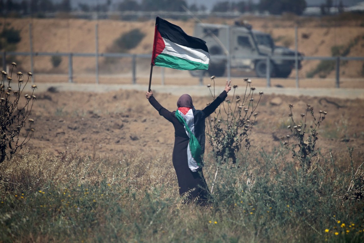 A woman holding a Palestinian flag gestures in front of Israeli forces during a protest marking the 71st anniversary of the ''Nakba'', or catastrophe, when hundreds of thousands fled or were forced from