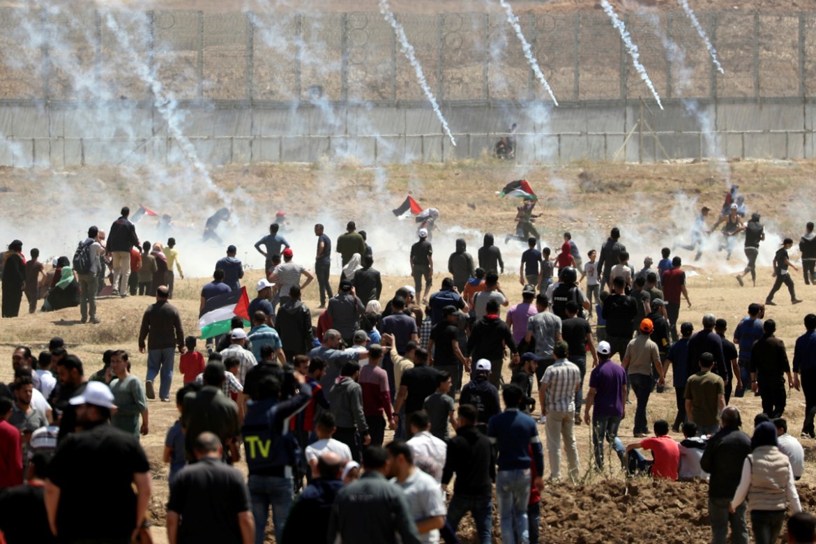 Palestinian demonstrators run for cover from tear gas canisters fired by Israeli forces during a protest marking the 71st anniversary of the ''Nakba'', or catastrophe, when hundreds of thousands fled or